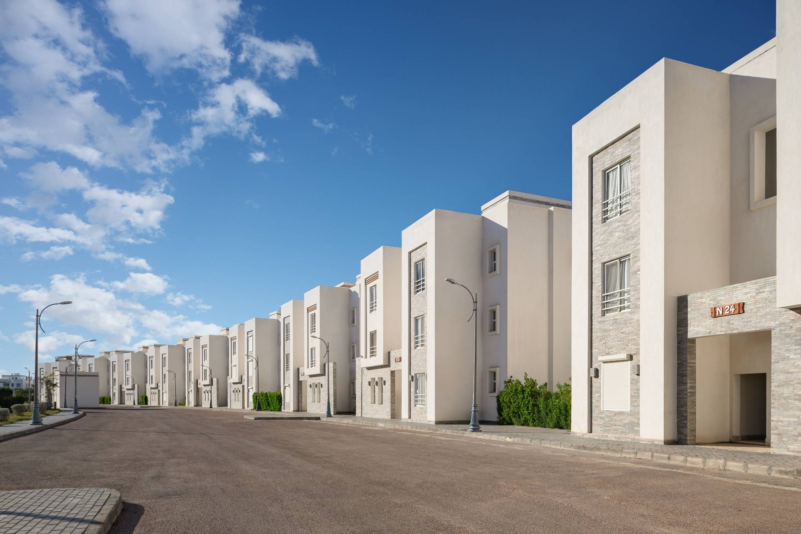 Street of white townhouses under a blue sky - chalet in Amwaj, North Coast