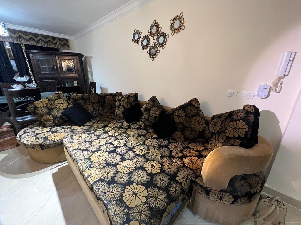 Floral L-shaped sofa under decorative wall mirrors - apartment in Dar Misr Al Andalus, 5th Settlement