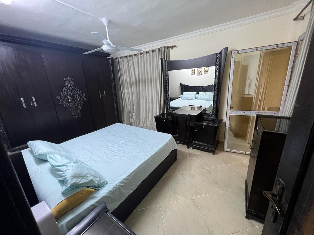 Bedroom with a dark wardrobe wall and light blue bedding - apartment in Dar Misr Al Andalus, 5th Settlement