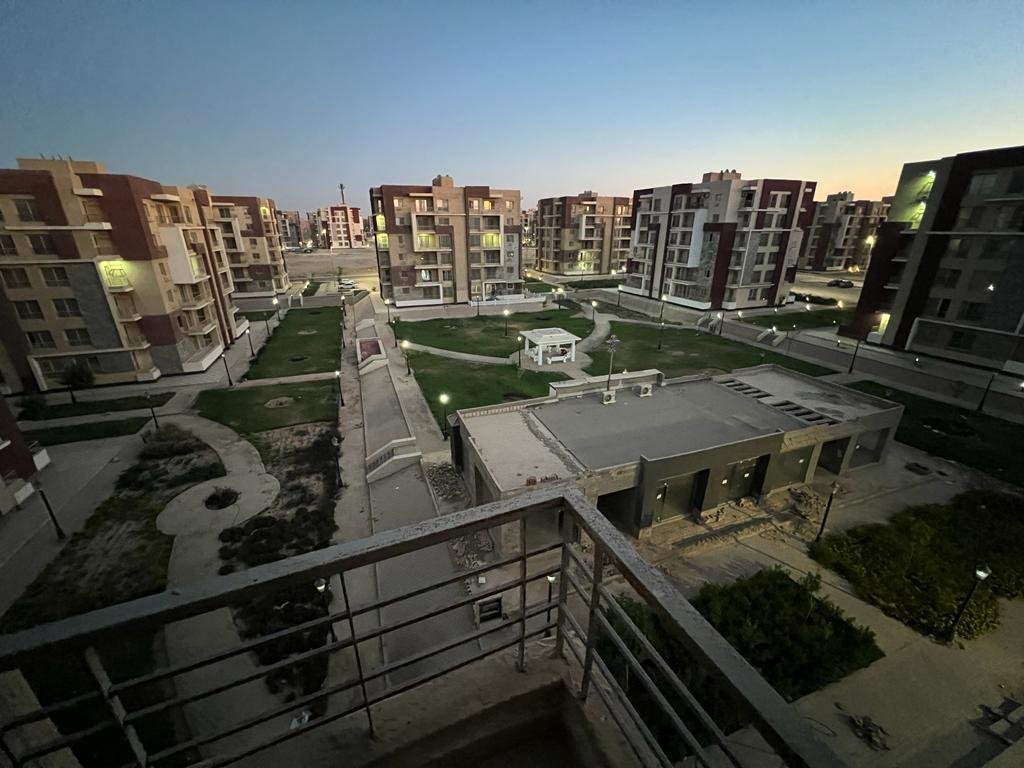 Balcony view over the courtyard and surrounding apartment blocks at dusk - apartment in Dar Misr Al Andalus, 5th Settlement