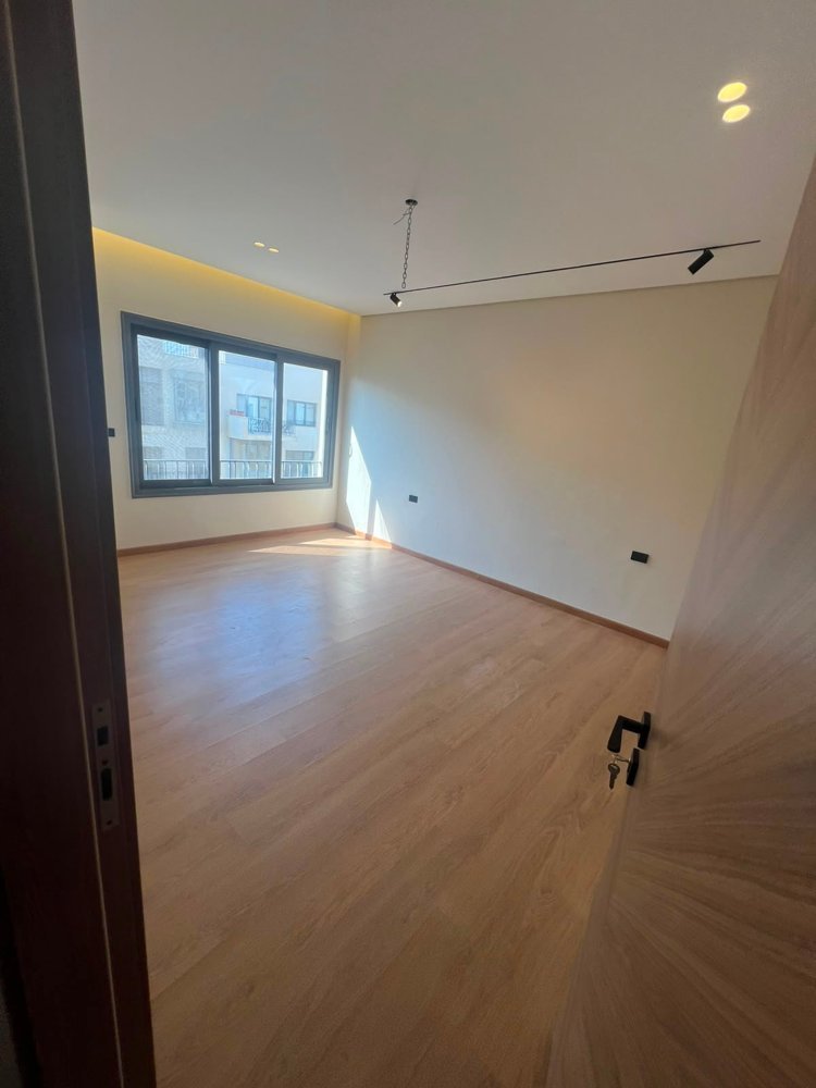 apartment-eastown-new-cairo-156-sqm-412-bedroom-2 Empty room with a laminate floor seen from the doorway - apartment in SODIC Eastown, New Cairo
