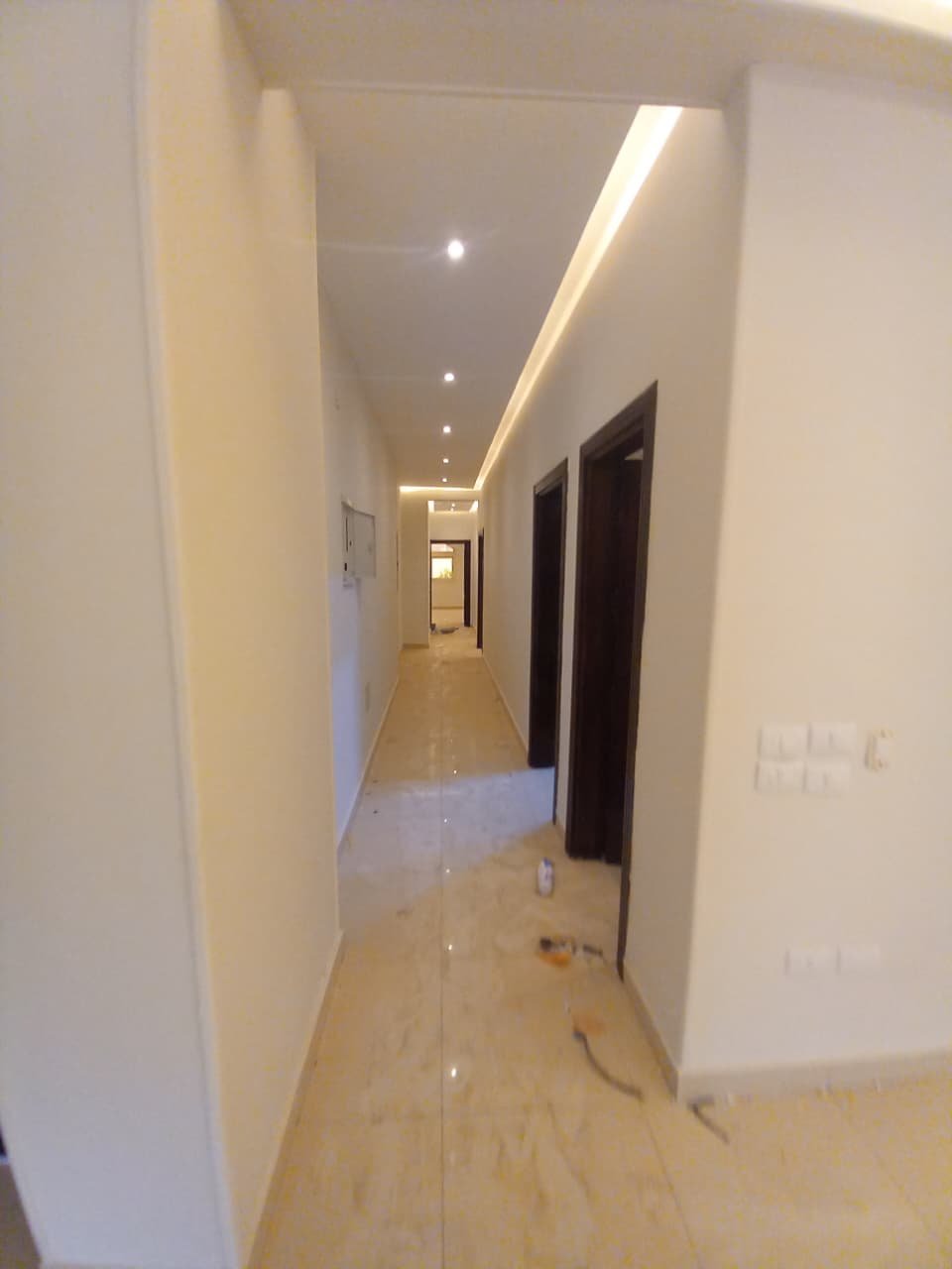 apartment-for-rent-administrative-al-narges-4-new-cairo-220-sqm-corridor ممر طويل بأبواب داكنة وأرضية رخام - فيلا في فيلات النرجس 4، القاهرة الجديدة