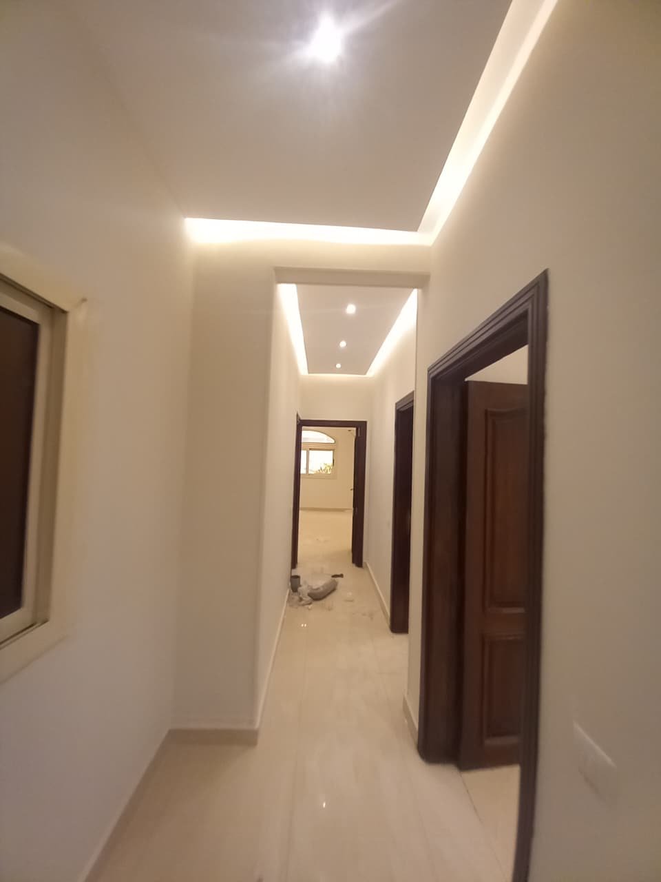 apartment-for-rent-administrative-al-narges-4-new-cairo-220-sqm-hallway ممر بسقف إضاءة مخفية وأبواب بني - فيلا في فيلات النرجس 4، القاهرة الجديدة
