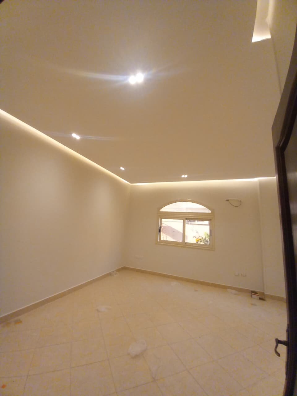 apartment-for-rent-administrative-al-narges-4-new-cairo-220-sqm-room-2 غرفة بسبوتات وسقف إضاءة مخفية وشباك مقوس صغير - فيلا في فيلات النرجس 4، القاهرة الجديدة