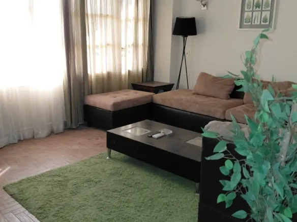 Furnished living room with corner sofa and green rug, apartment for rent in El Yasmeen 1 villas