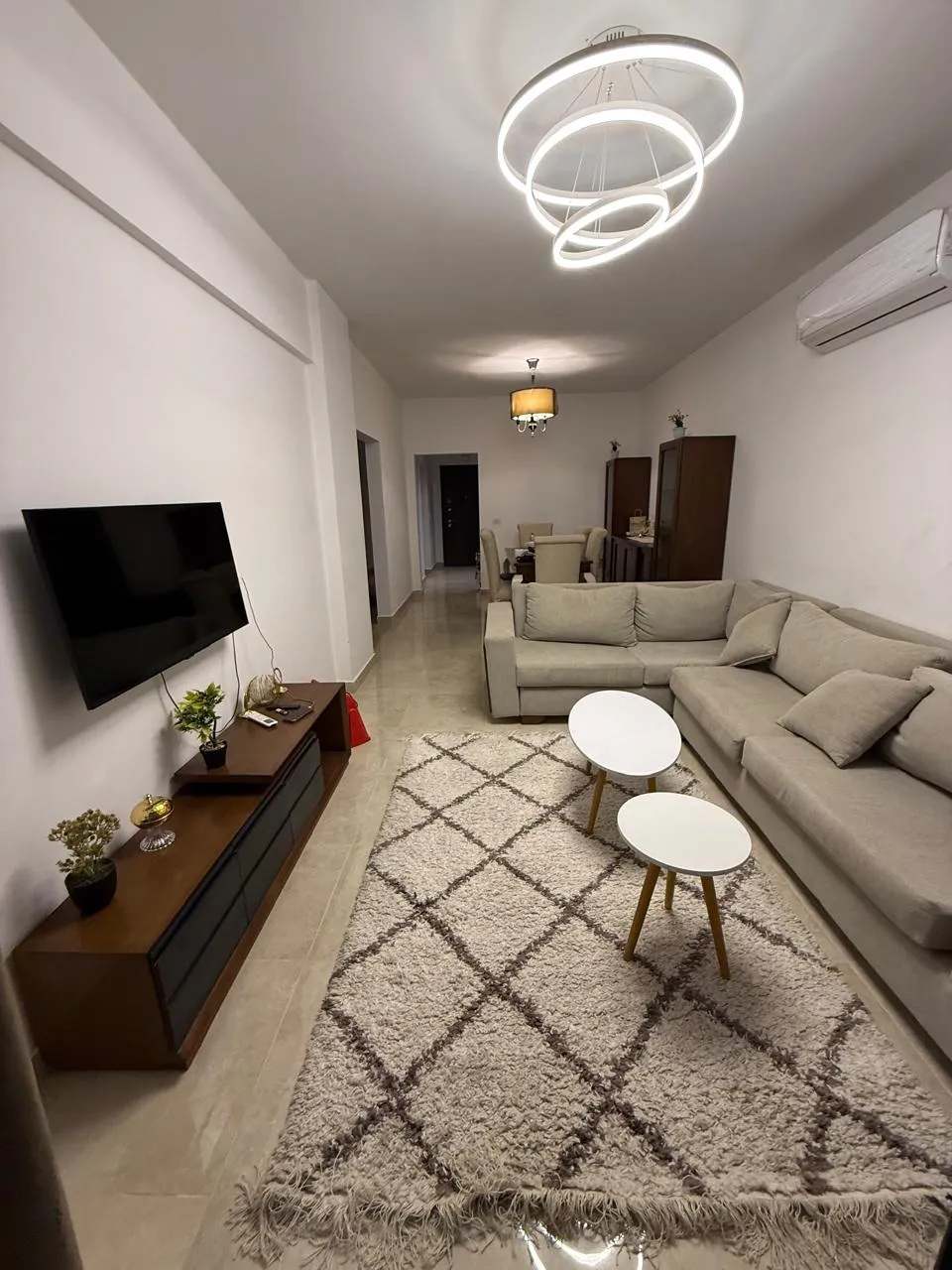 Furnished living room with corner sofa and TV, apartment for rent in Fifth Square New Cairo - غرفة معيشة مفروشة بركنة وتلفزيون، شقة للإيجار في فيفث سكوير القاهرة الجديدة