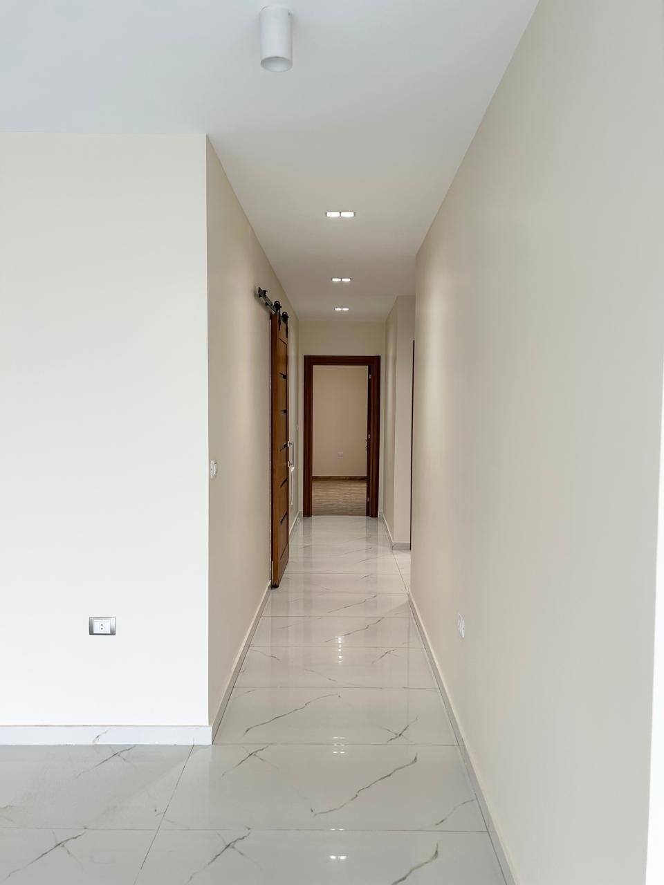 Hallway with marble floor and wooden door, Lake View Residence apartment