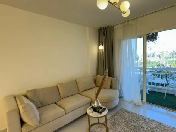 Furnished living room with sofa and balcony view, apartment for rent in Madinaty