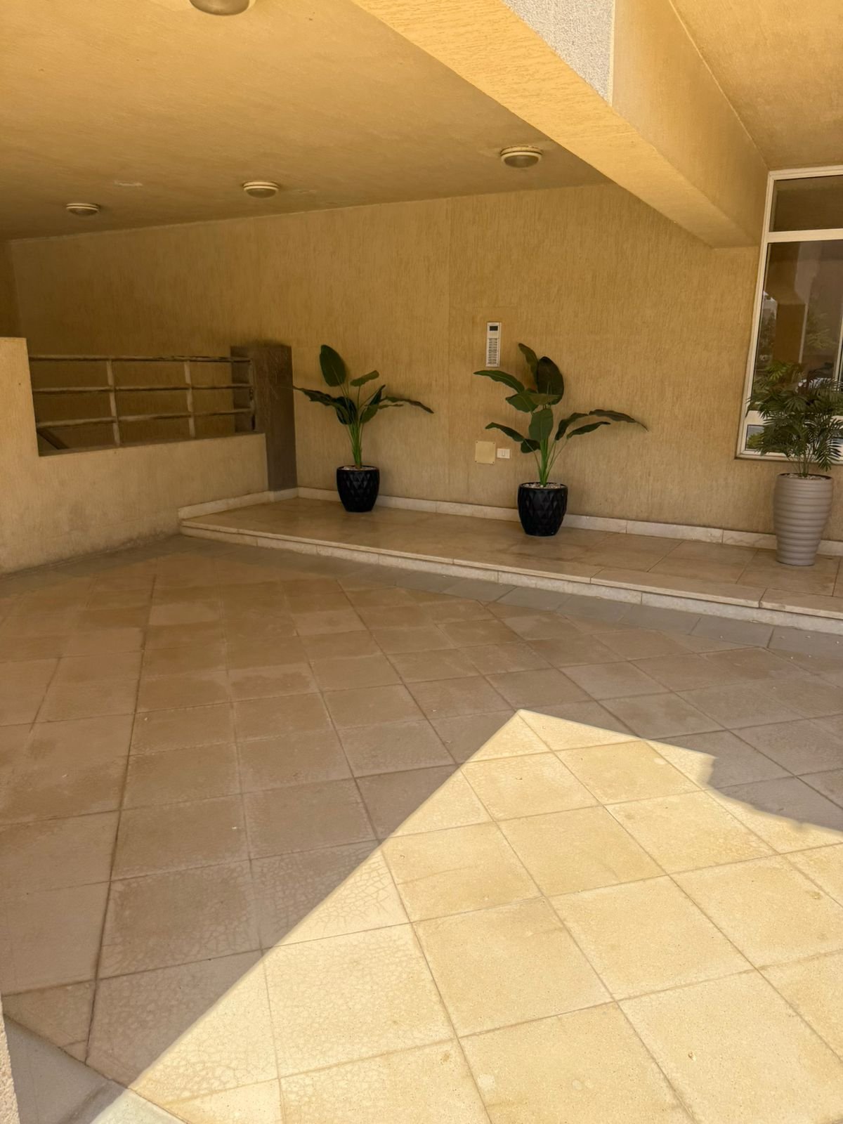 Entrance hall with tiled floor and plants - apartment in Fifth Square, New Cairo