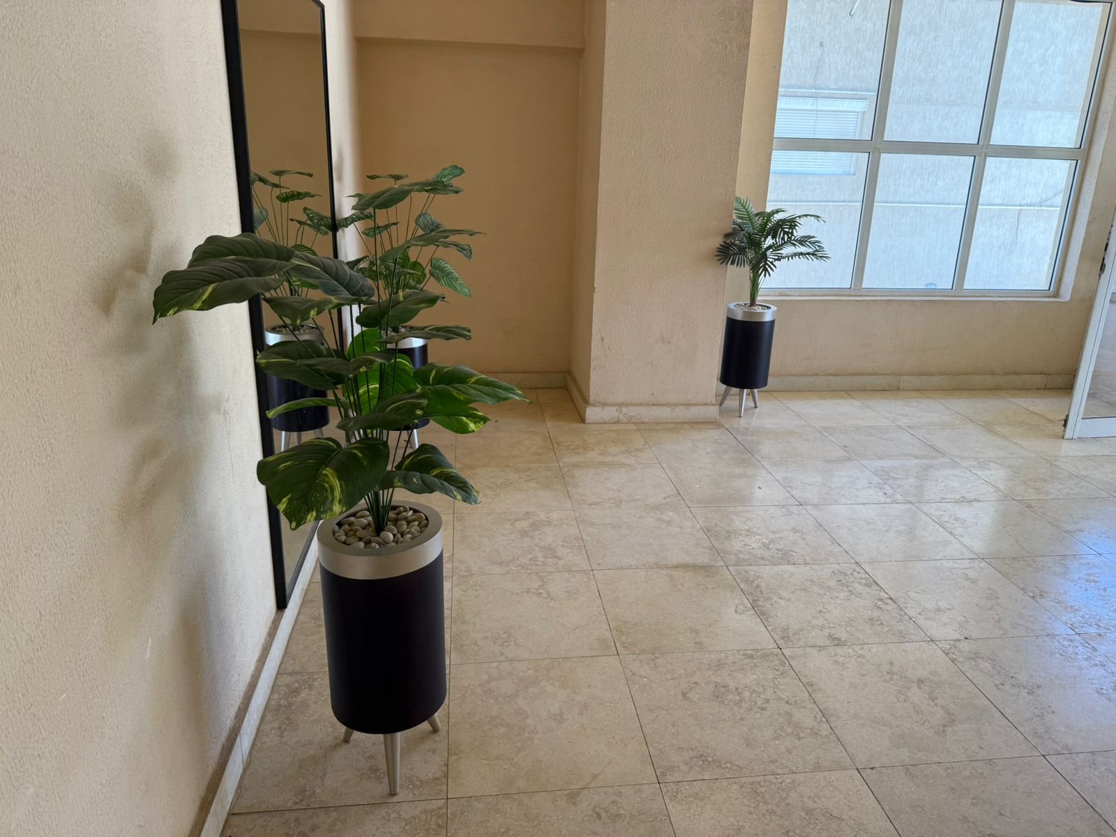 Hall with plants and large window - apartment in Fifth Square, New Cairo