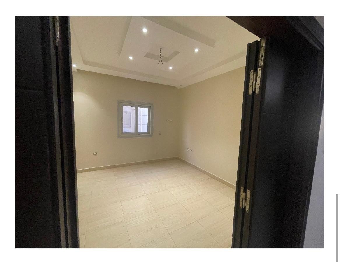 apartment-for-sale-al-banafseg-6-new-cairo-210-sqm-bedroom-2 غرفة نوم من خلال إطار باب داكن مفتوح - شقة في البنفسج 6، القاهرة الجديدة