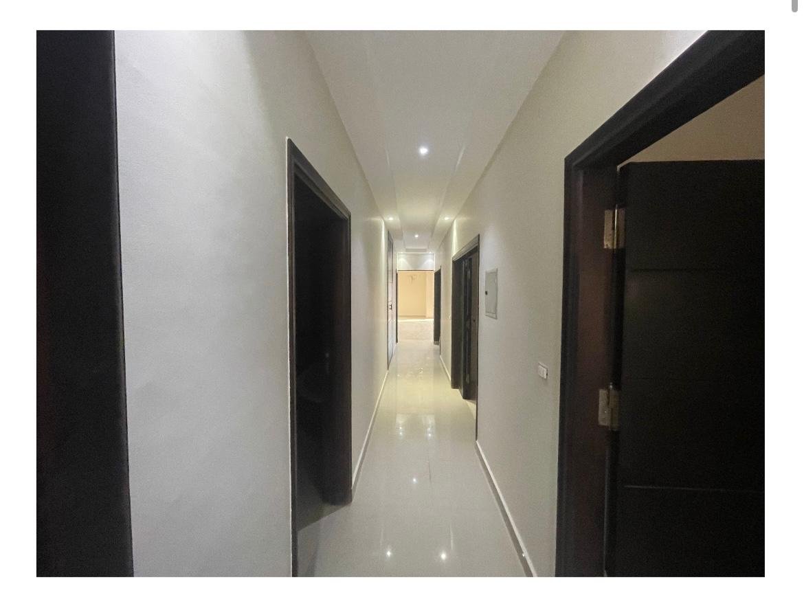 apartment-for-sale-al-banafseg-6-new-cairo-210-sqm-hallway ممر طويل منور بأبواب داكنة على الجانبين - شقة في البنفسج 6، القاهرة الجديدة