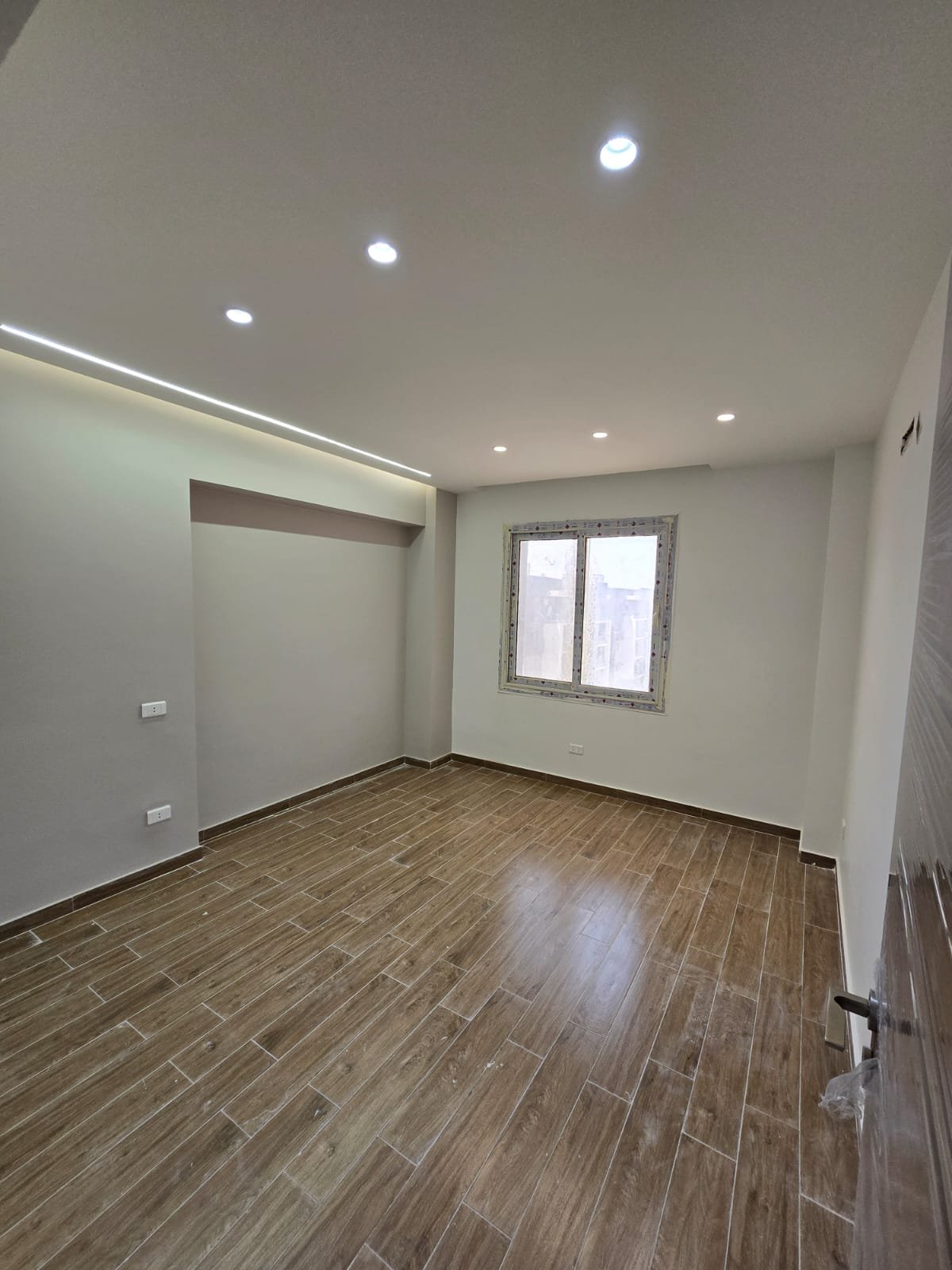 apartment-for-sale-dar-misr-al-andalus-new-cairo-130-sqm-bedroom غرفة بأرضية شبه الخشب وشباك - شقة في دار مصر الأندلس، القاهرة الجديدة
