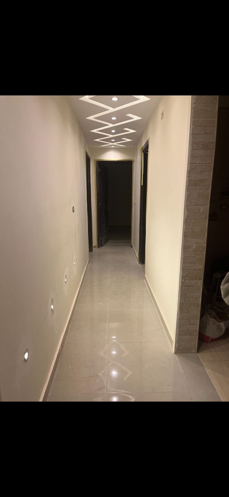Dark narrow corridor with recessed ceiling lights - apartment in Eazy Life, New Cairo