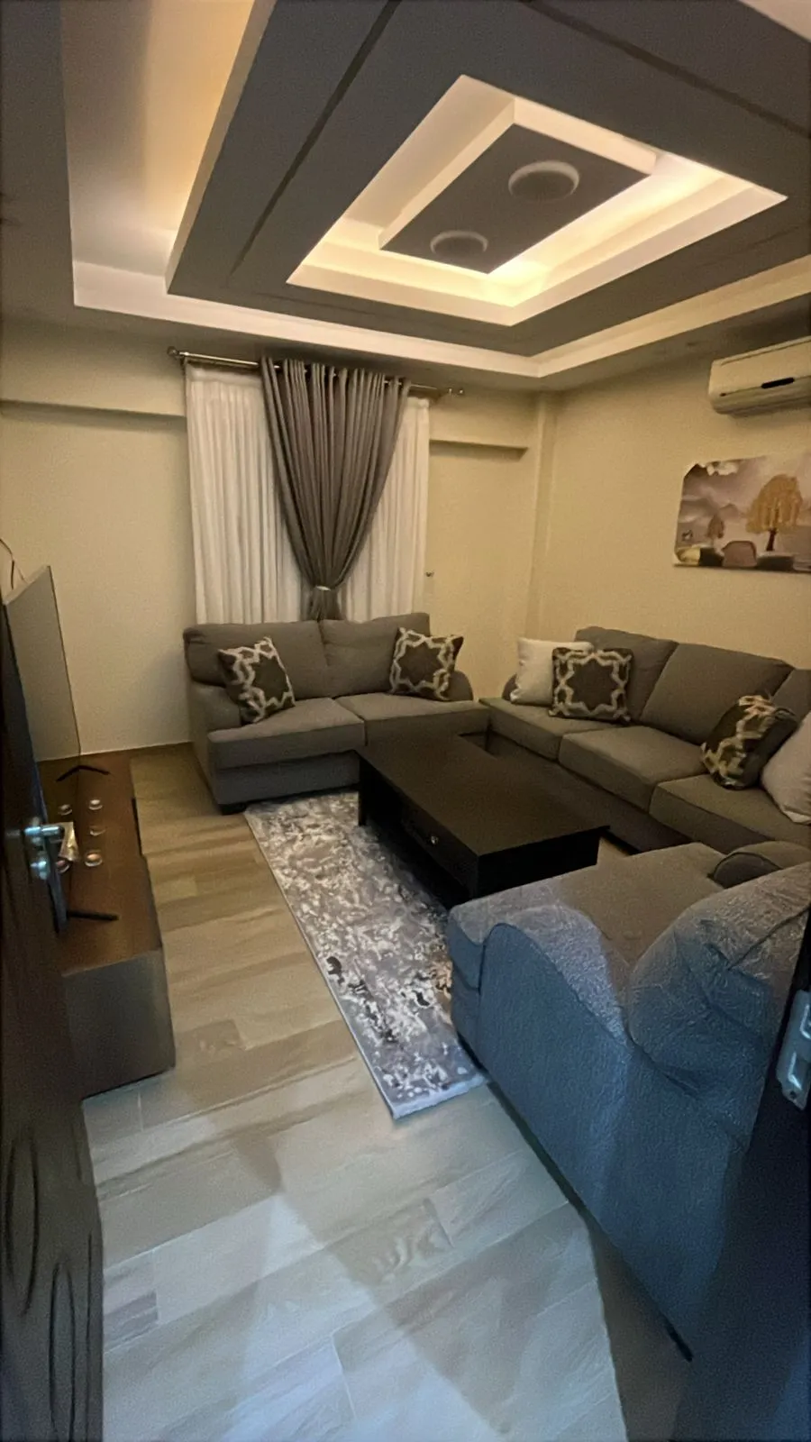 Living room with a dark sofa and a ceiling light frame - apartment in Eazy Life, New Cairo