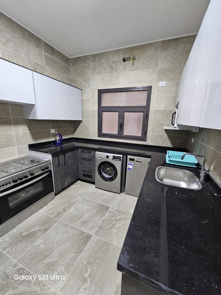 apartment-moon-residences-5th-square-new-cairo-167-sqm-397-kitchen مطبخ بكاونتر أسود وغسالة - شقة في مون ريزيدنس فيفث سكوير، القاهرة الجديدة
