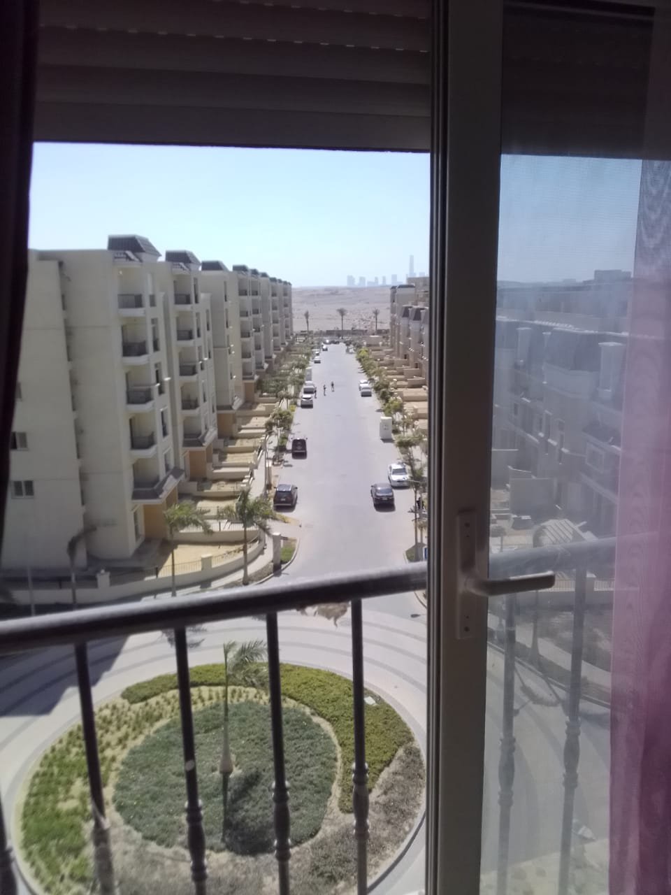 Balcony window view over a street with a roundabout and apartment blocks - apartment in Sarai, Mostaqbal City
