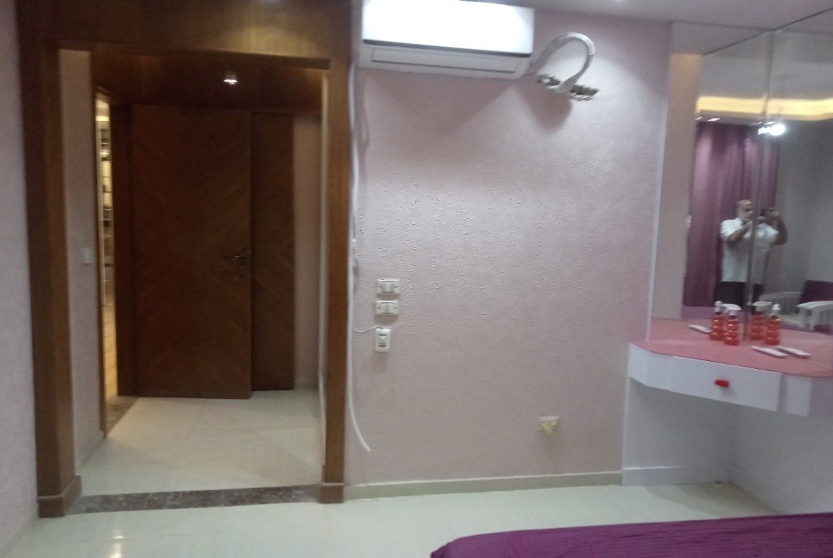 Dressing area with a pink vanity and a wooden doorway - apartment in Sarai, Mostaqbal City