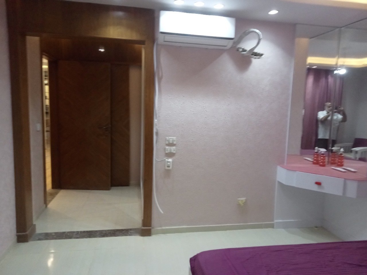 Dressing area with a pink vanity and a wooden doorway - apartment in Sarai, Mostaqbal City
