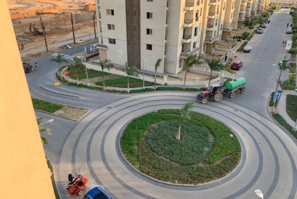 Aerial view of a roundabout garden and a road between apartment buildings - apartment in Sarai, Mostaqbal City
