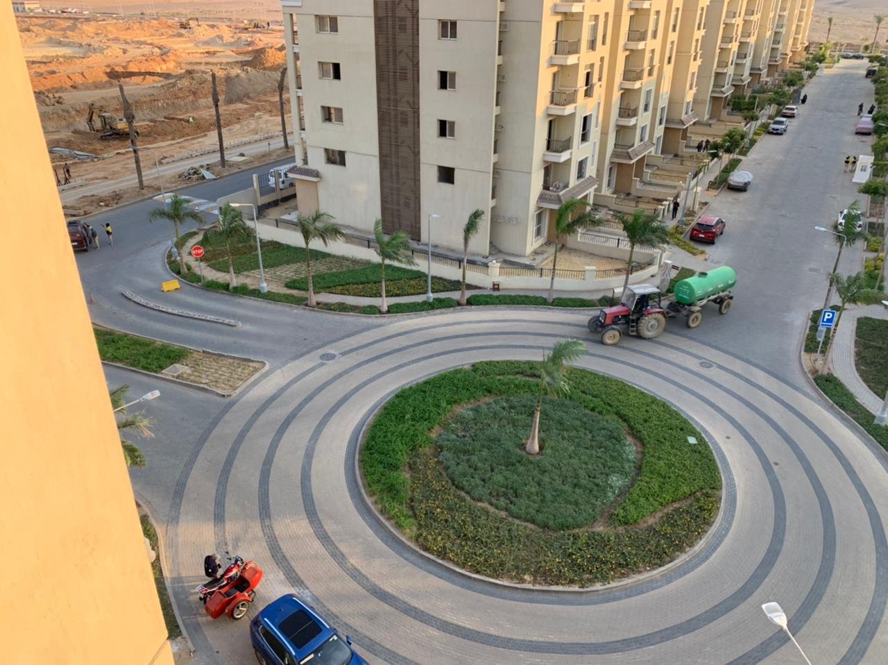 Aerial view of a roundabout garden and a road between apartment buildings - apartment in Sarai, Mostaqbal City