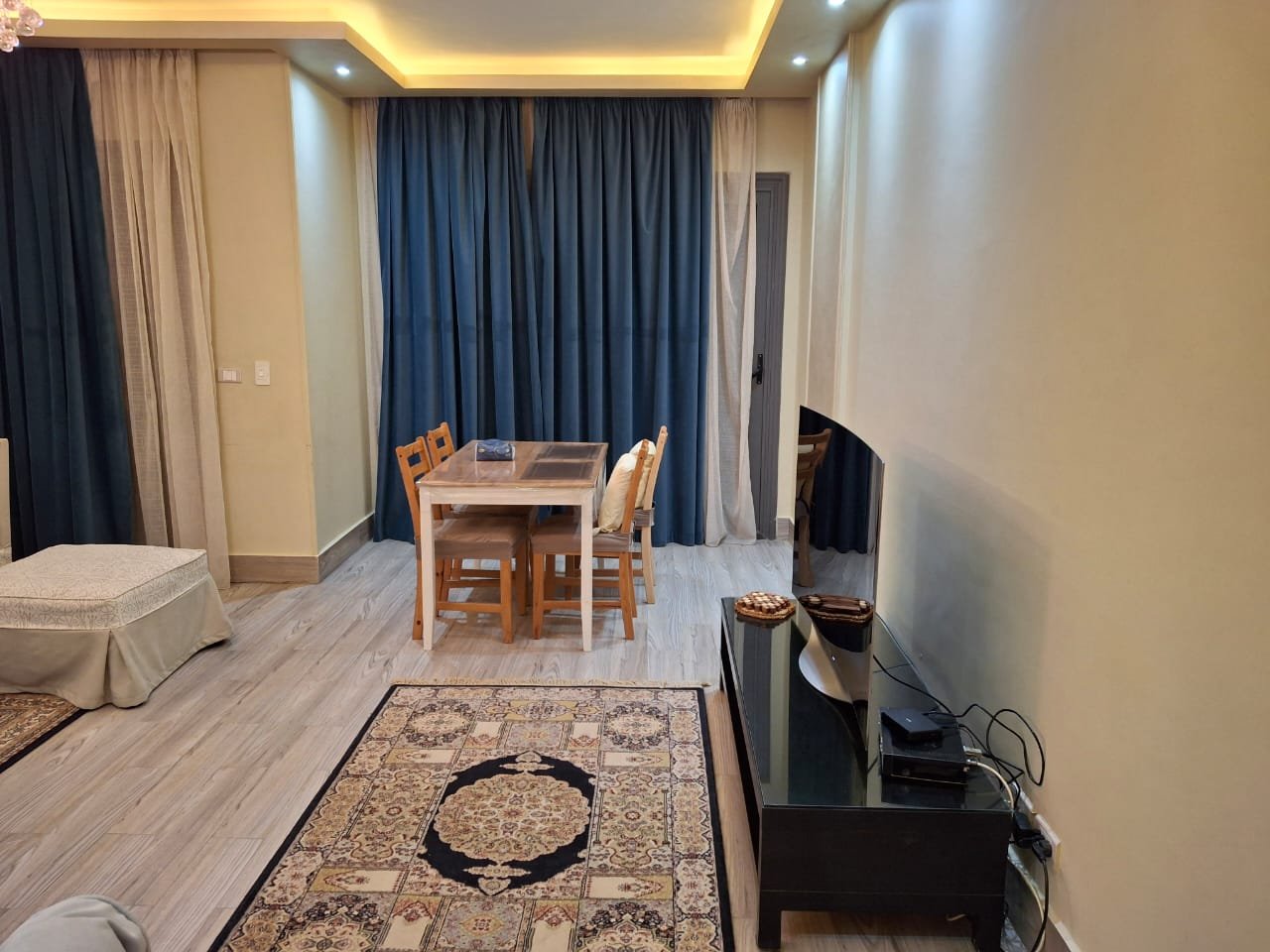 apartment-rent-tag-sultan-taj-city-34-dining-area منطقة سفرة وتلفزيون مع ستائر زرقاء - شقة في تاج سلطان