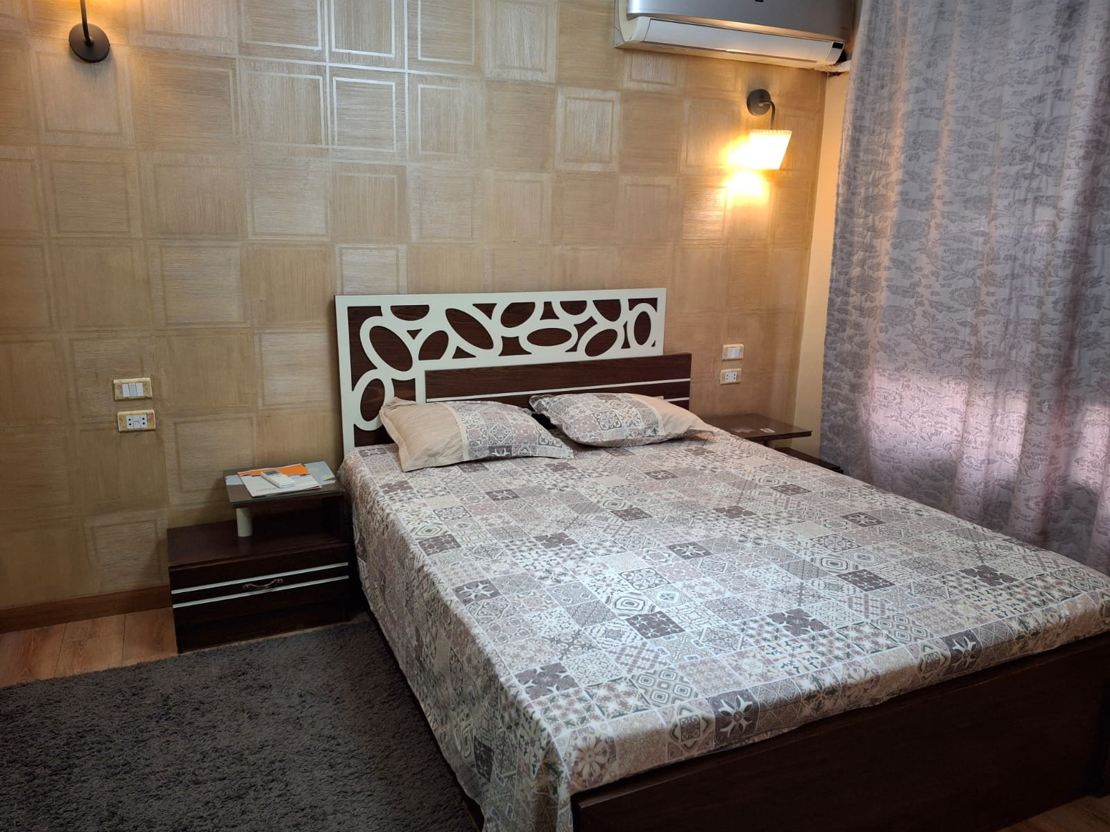 apartment-rent-tag-sultan-taj-city-34-master-bedroom-2 غرفة نوم مع ظهر سرير منحوت وإضاءة جدارية - شقة في تاج سلطان