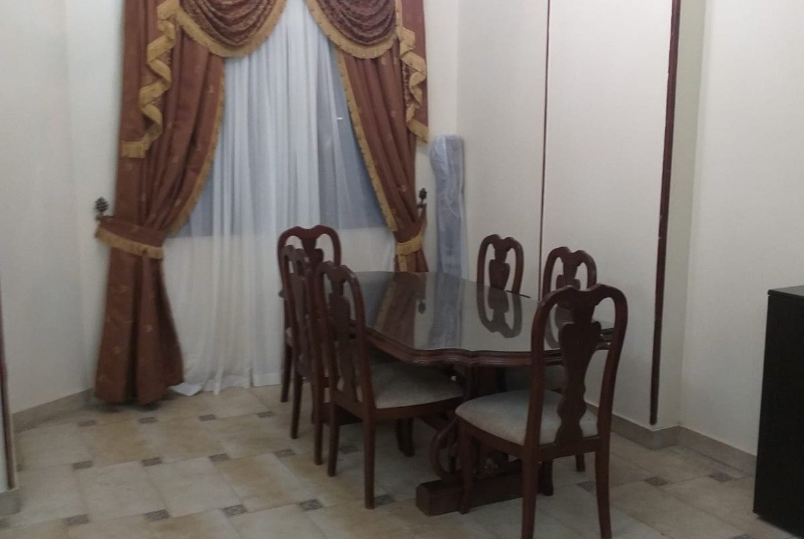 Dining table with chairs and curtains with gold trim - apartment in Yasmeen 3, New Cairo