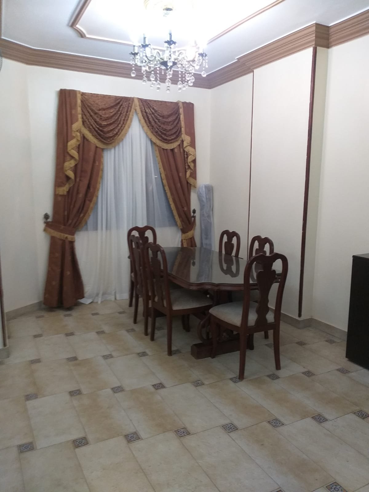 Dining table with chairs and curtains with gold trim - apartment in Yasmeen 3, New Cairo