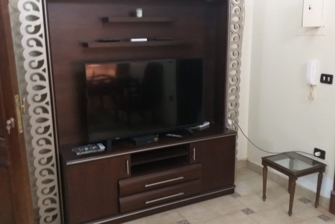 TV unit with a decorative frame beside a side table - apartment in Yasmeen 3, New Cairo