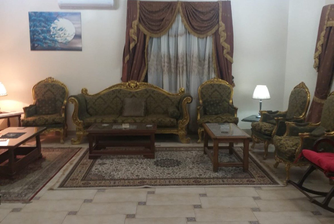 Sitting room with classic armchairs and brown curtains - apartment in Yasmeen 3, New Cairo