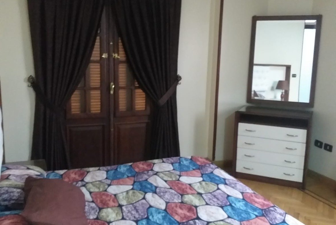 Bed with a colourful patchwork cover and a dressing table - apartment in Yasmeen 3, New Cairo