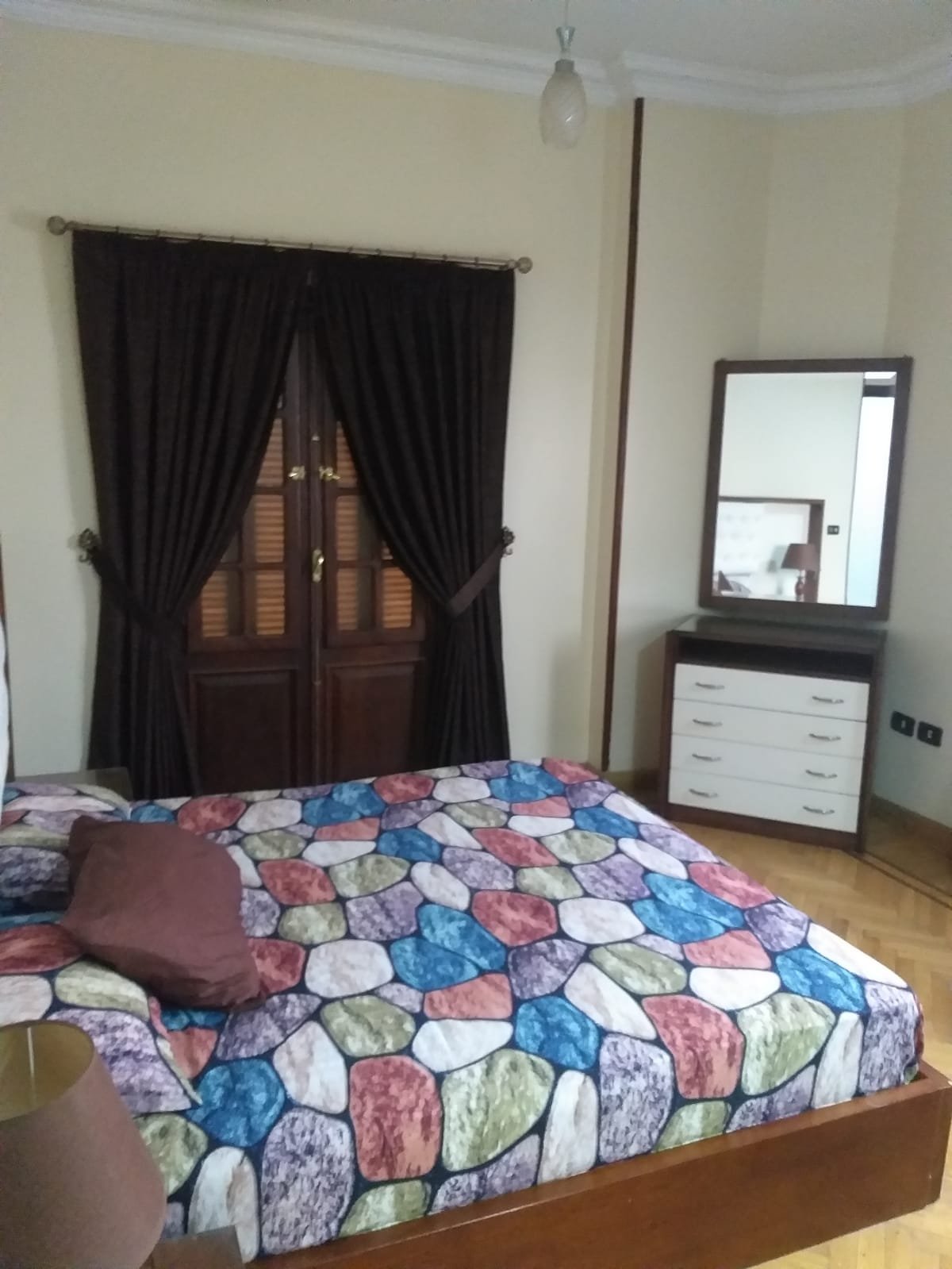 Bed with a colourful patchwork cover and a dressing table - apartment in Yasmeen 3, New Cairo