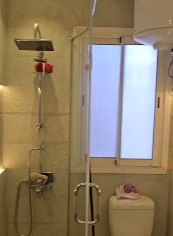 Compact bathroom with a shower and small window - apartment in Taj City, New Cairo