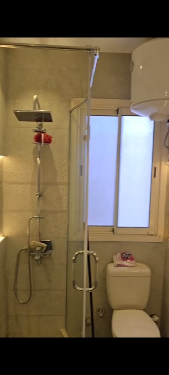 apartment-sale-taj-city-zone-t-36-bathroom Compact bathroom with a shower and small window - apartment in Taj City, New Cairo