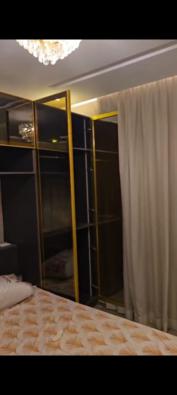 apartment-sale-taj-city-zone-t-36-bedroom-wardrobe Bedroom with a dark fitted wardrobe - apartment in Taj City, New Cairo