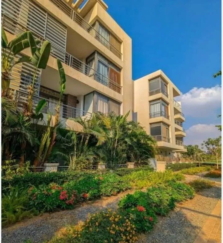 Yellow apartment buildings with landscaped gardens - apartment in Taj City, New Cairo
