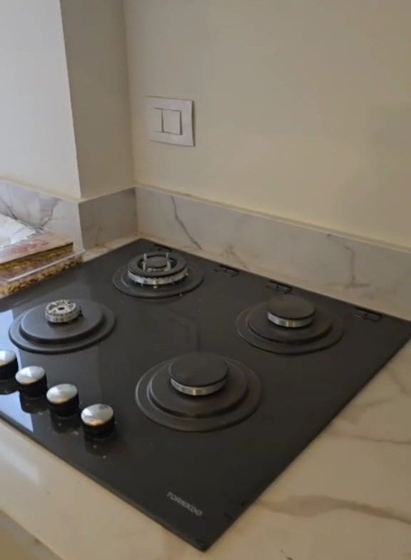 Kitchen counter with a black built-in hob - apartment in Taj City, New Cairo