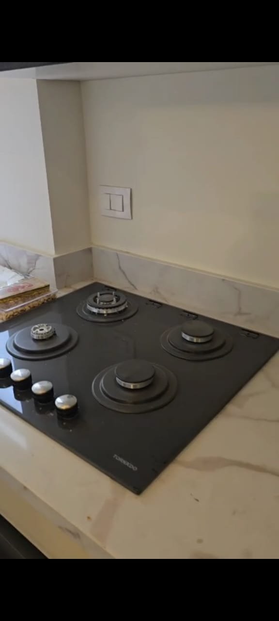 apartment-sale-taj-city-zone-t-36-kitchen-hob Kitchen counter with a black built-in hob - apartment in Taj City, New Cairo