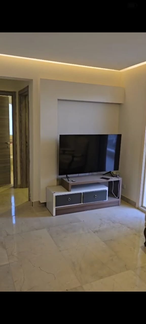 apartment-sale-taj-city-zone-t-36-living-room Compact living room with a TV unit - apartment in Taj City, New Cairo