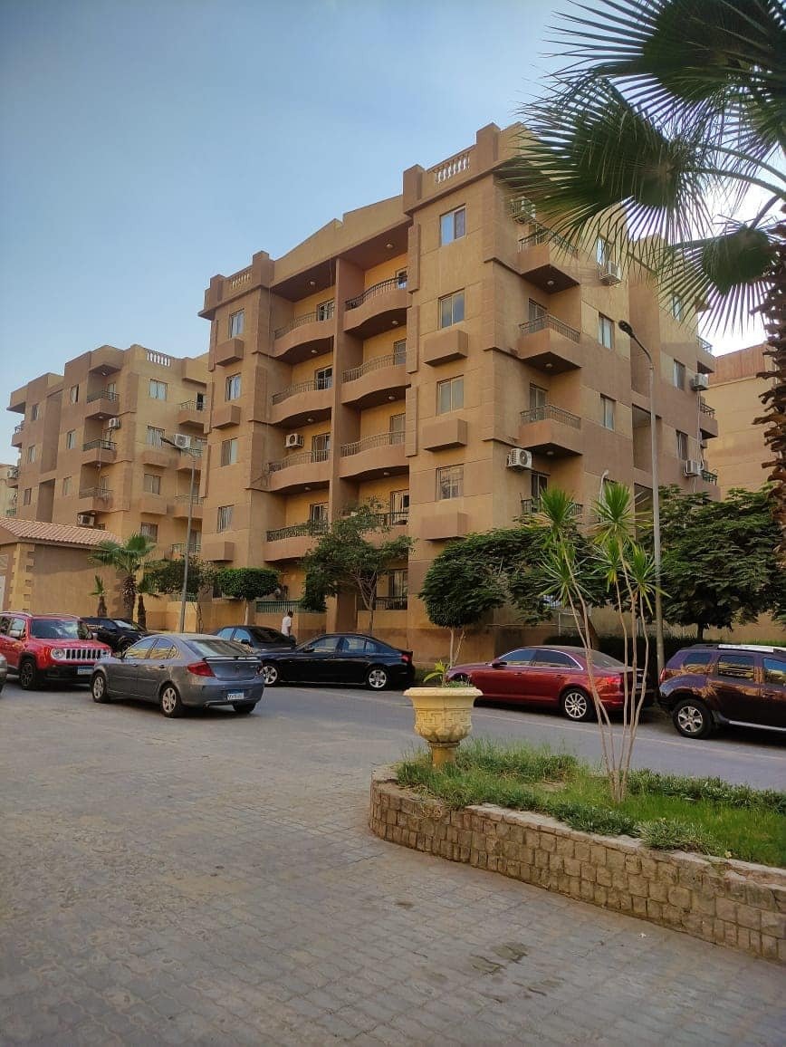 ashrafeya-residence-new-cairo-buildings Apartment buildings behind a parking area and a planted corner - apartment in Ashrafeya Residence, New Cairo