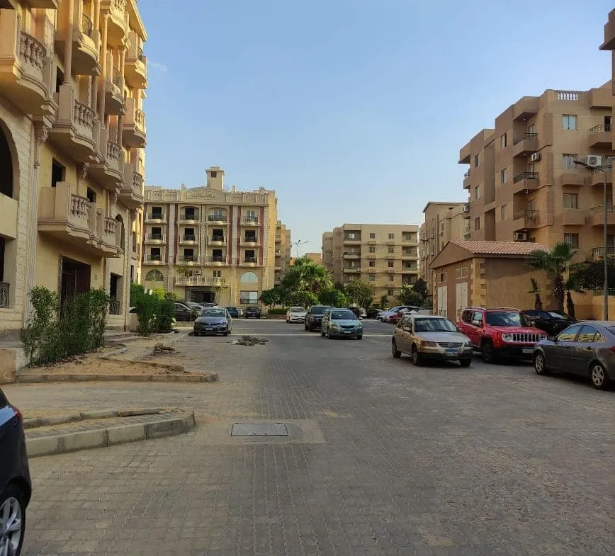 Quiet street between apartment buildings with parked cars - apartment in Ashrafeya Residence, New Cairo