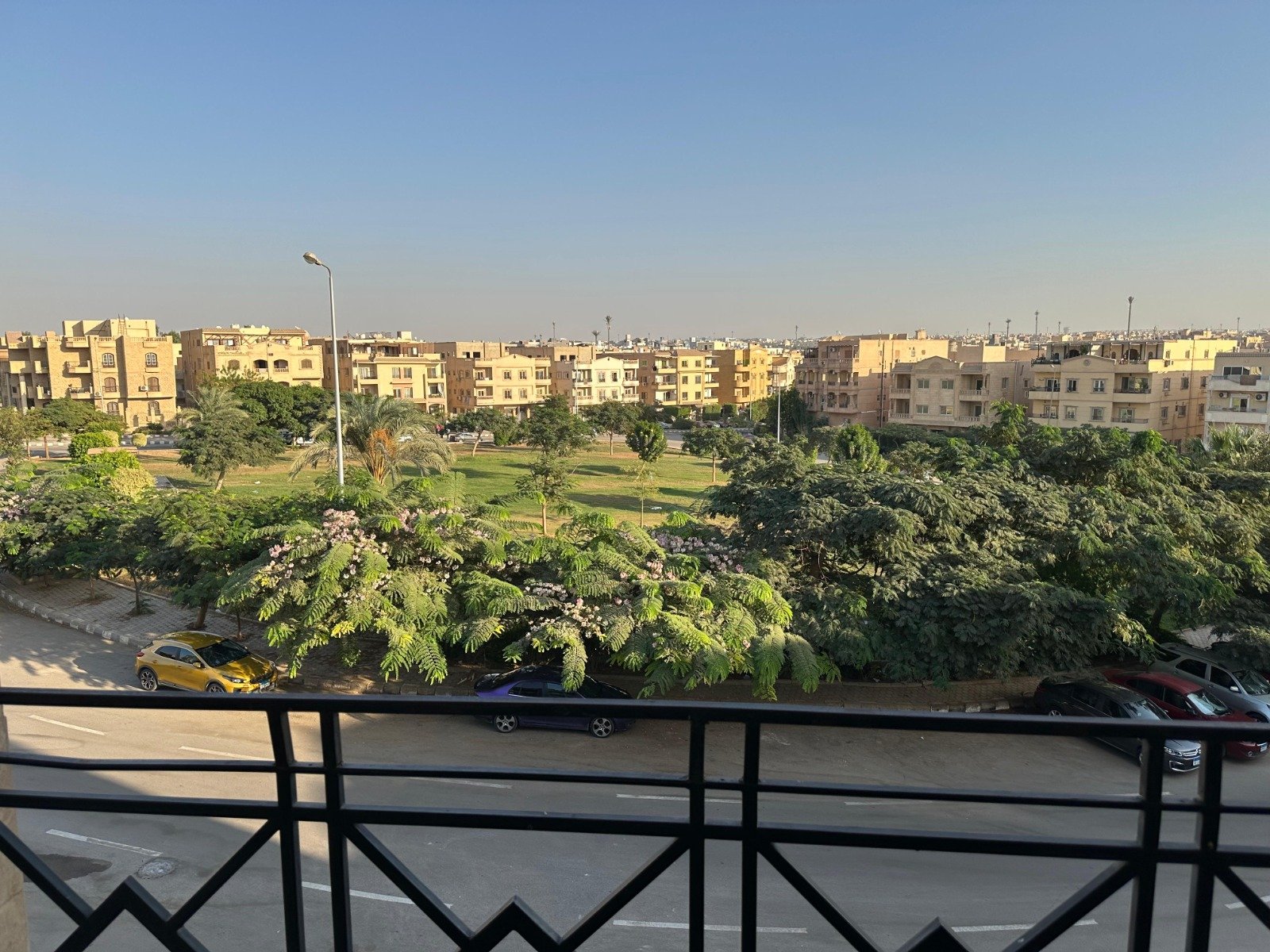 banafseg10-apt-201-1 Balcony railing overlooking green trees and low-rise blocks - apartment in Al Banafseg 10, New Cairo