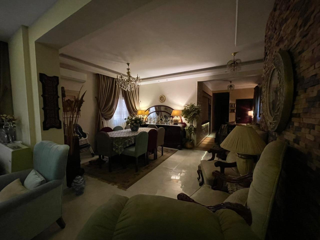 banafseg10-apt-201-5 Living and dining space with warm lamps and a stone accent wall - apartment in Al Banafseg 10, New Cairo
