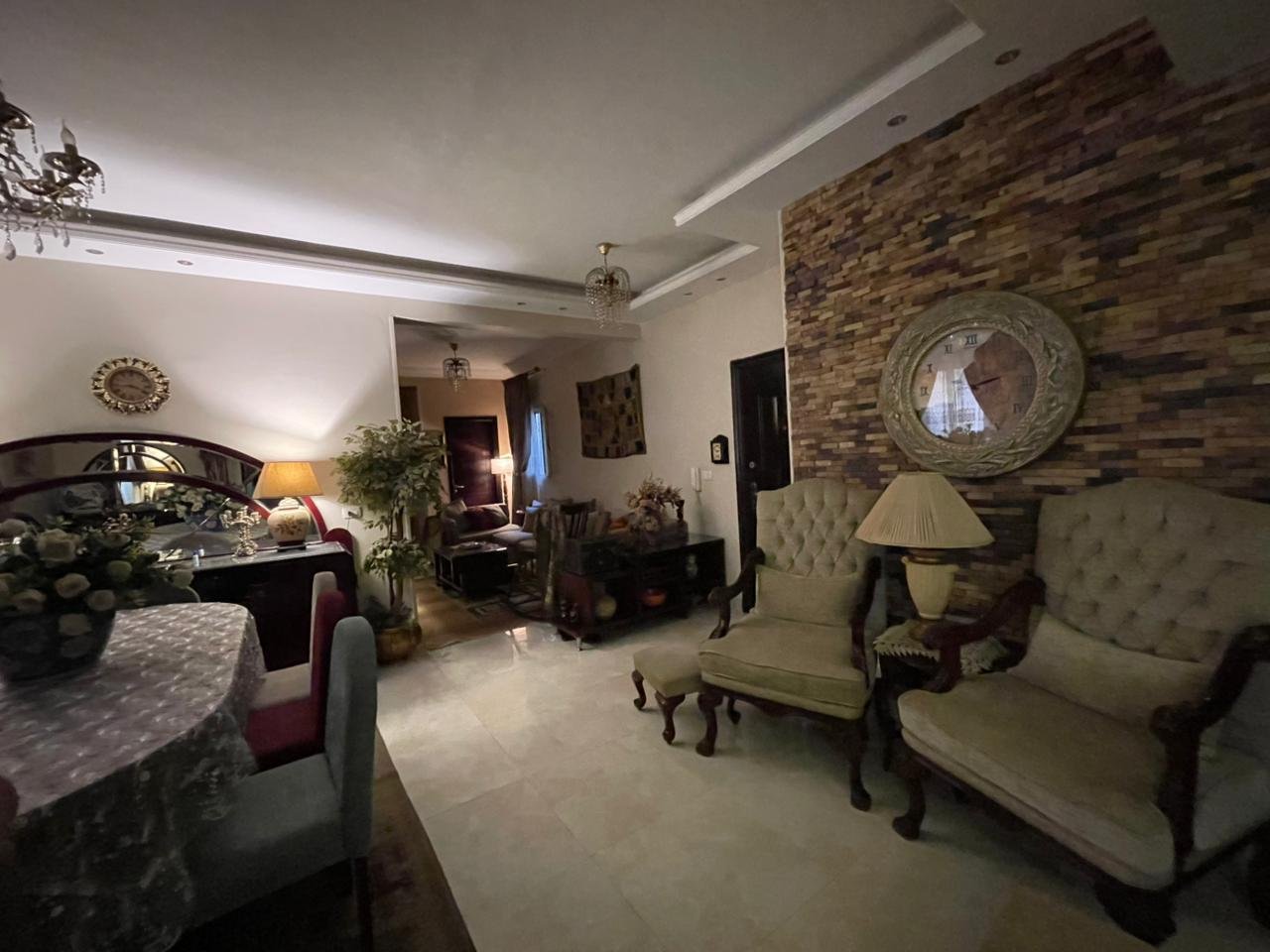 banafseg10-apt-201-6 Sitting area with upholstered chairs and a stone feature wall - apartment in Al Banafseg 10, New Cairo