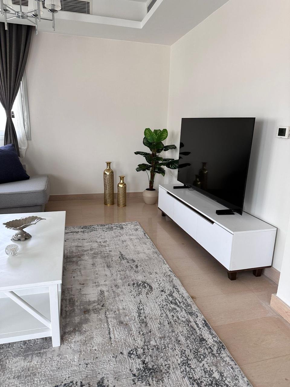 cfc-apt-rent-109-05 وحدة تلفزيون وسجادة في غرفة معيشة بيضاء - شقة في كايرو فيستيفال سيتي التجمع الخامس – 3 غرف 200 متر، القاهرة الجديدة