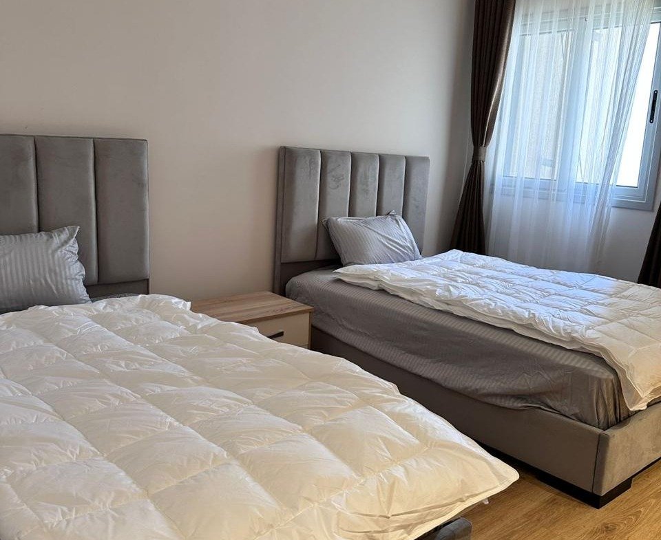 سريران برأس رمادي وألحفة بيضاء - شقة في كايرو فيستيفال سيتي التجمع الخامس – 3 غرف 200 متر، القاهرة الجديدة