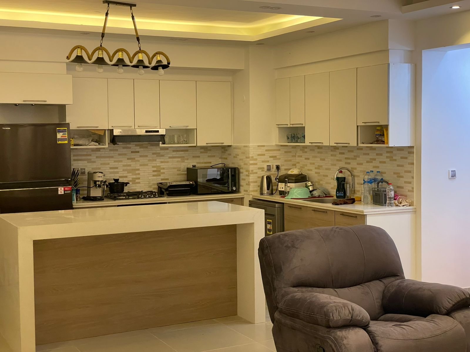 chalet-sale-marassi-marina1-kitchen Kitchen with island and brown armchair - chalet in Marassi Marina 1, North Coast