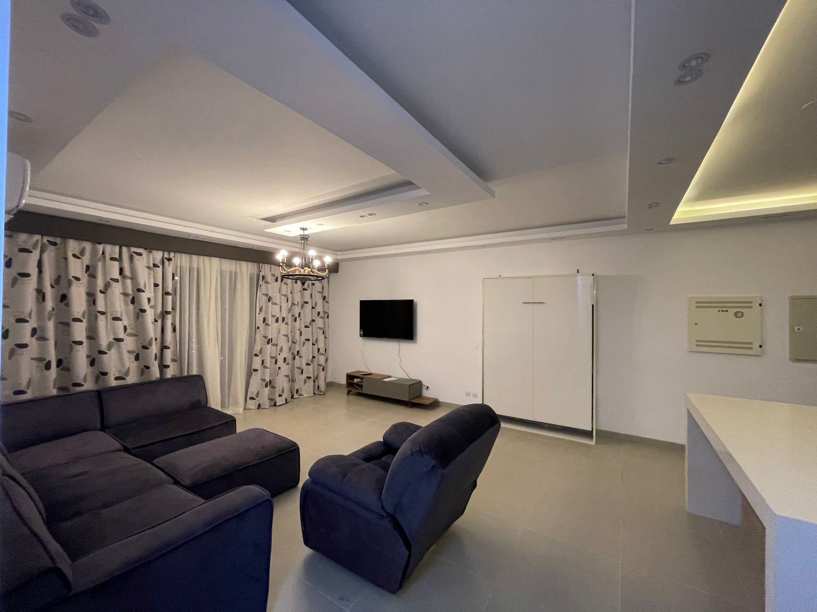 chalet-sale-marassi-marina1-reception Living room with dark corner sofa and ceiling lights - chalet in Marassi Marina 1, North Coast