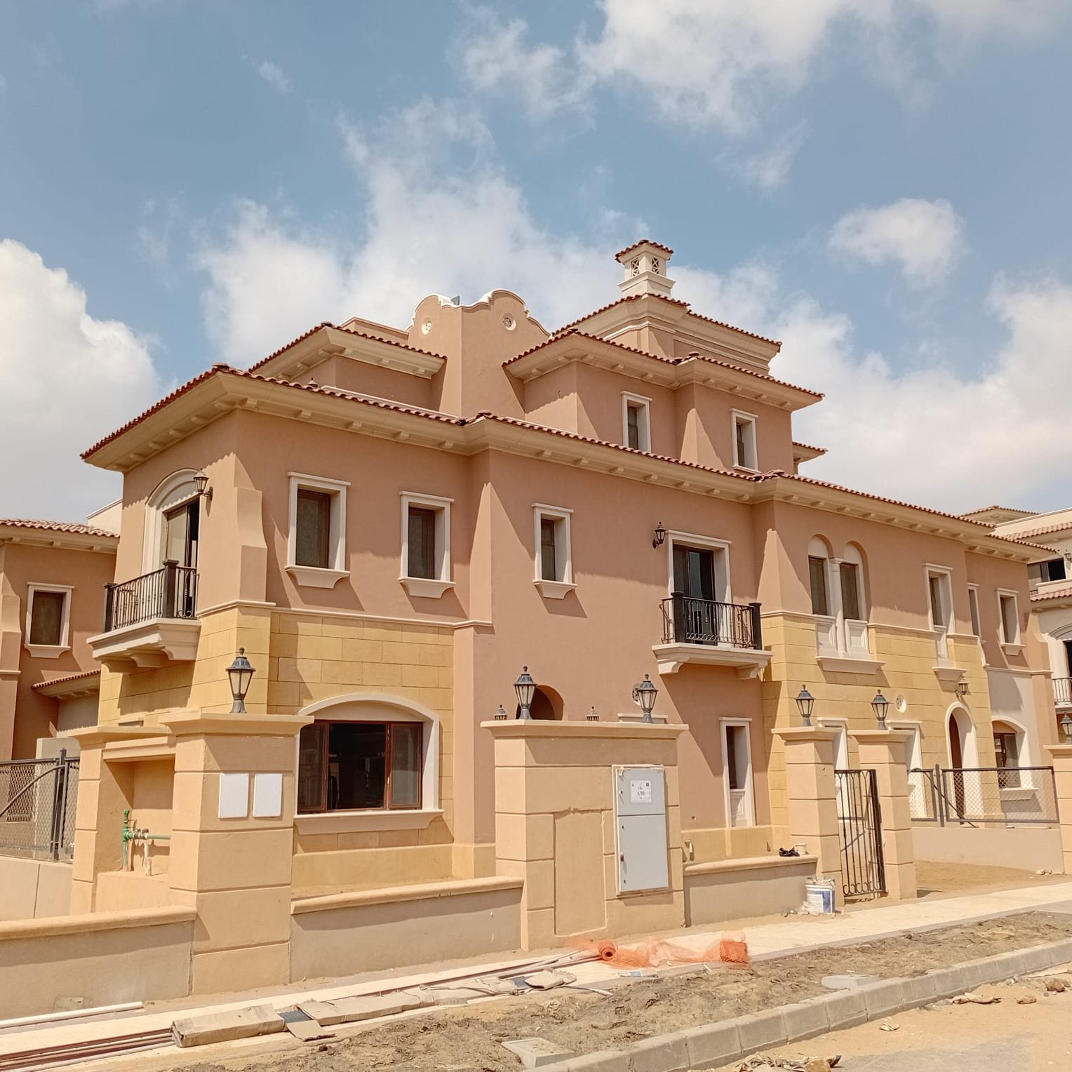فيلا كواترو للبيع في سيتي جيت Villas with terracotta walls seen from the street corner - villa in CityGate, New Cairo
